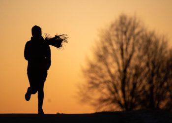 Eine Joggerin läuft in der Dämmerung.