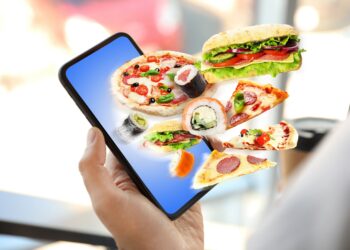 Grafische Darstellung eines Smartphones, aus dem ungesunde Lebensmittel wie Pizza und Burger herausfliegen.