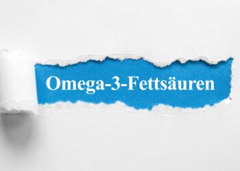 De Schriftzug Omega-3-Fettsäuren unter aufgerissenem Papier