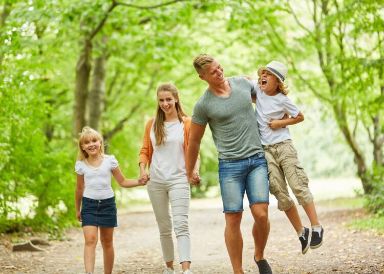 Glückliche Familie beim entspannten Spaziergang in der grünen Natur