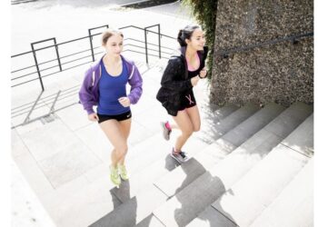 Zwei Frauen joggen eine Treppe hinauf.