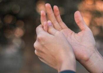 Junge Frau hält ihre schmerzende Hand