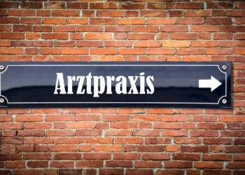 Backsteinmauer mit einem Schild mit der Aufschrift Arztpraxis