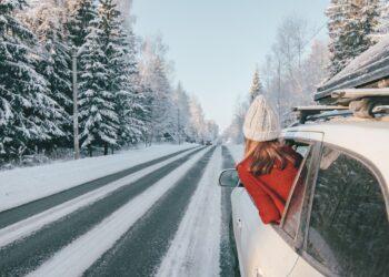 Eine Frau steckt ihren Kopf aus dem Fenster eines Autos.