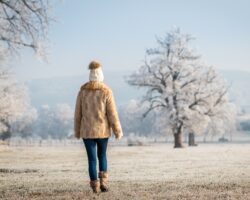 Frau macht einen Spaziergang in winterlicher Landschaft