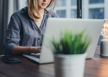 Eine junge Frau arbeitet am Laptop im Homeoffice