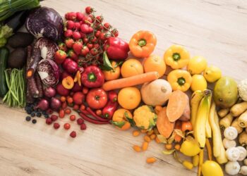 Eine Auswahl an Obst und Gemüse auf einer hölzernen Oberfläche.