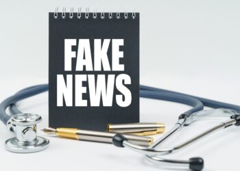 Auf einem Schreibblock steht "Fake News", daneben liegt ein Stetoskop.