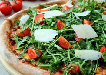 Rucola macht sich auch sehr gut auf Pizza. Dazu sollten Sie ihn aber erst nach dem Backen hinzufügen. (Bild: denio109/stock.adobe.com)