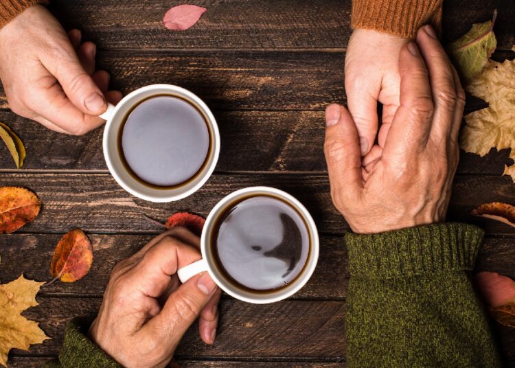 Zwei Tassen Kaffee stehen auf einer hölzernen Oberfläche.