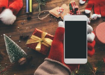 Ein Smartphone zwischen Weihnachtsdekoration.