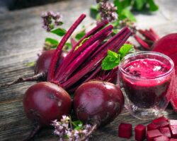 Rote Bete und Rote-Bete-Saft auf einer hölzernen Oberfläche.