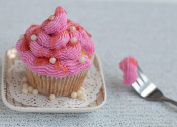 Rosafarbener Muffin auf einem kleinen Teller