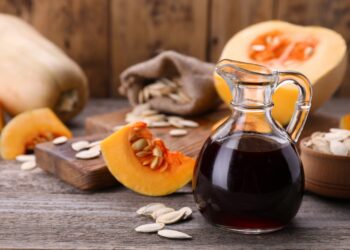 Fresh pumpkin seed oil in glass jug on wooden table. (Bild:  New Africa/stock.adobe.com)