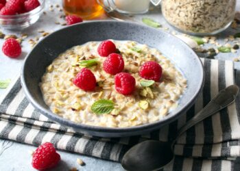 Eine Portion Haferflocken mit Himbeeren garniert.