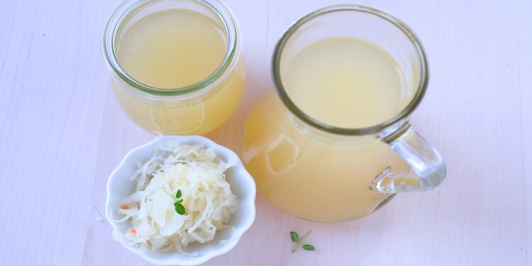 Sauerkraut in einer Schale und zwei Kannen mit Sauerkrautsaft.