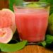 Guaven-Frucht und ein Glas mit Guavensaft in Großaufnahme.